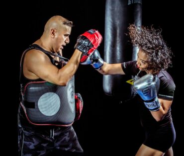 woman punching the hand of man wearing training gloves