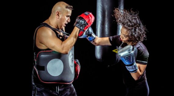 woman punching the hand of man wearing training gloves